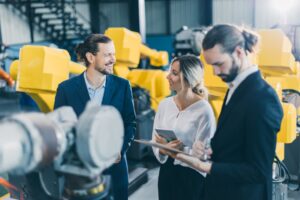 Des experts évaluent des bras robotisés en usine pour ajuster un contrat d'assurance en fonction de l'Indice RI.